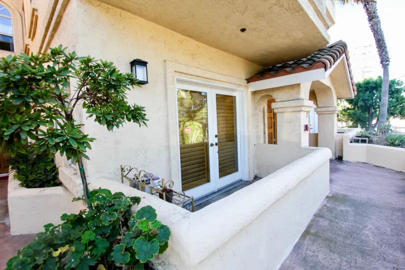 Front of a house in big front door and some plants in its front yard in the Uptown Villas