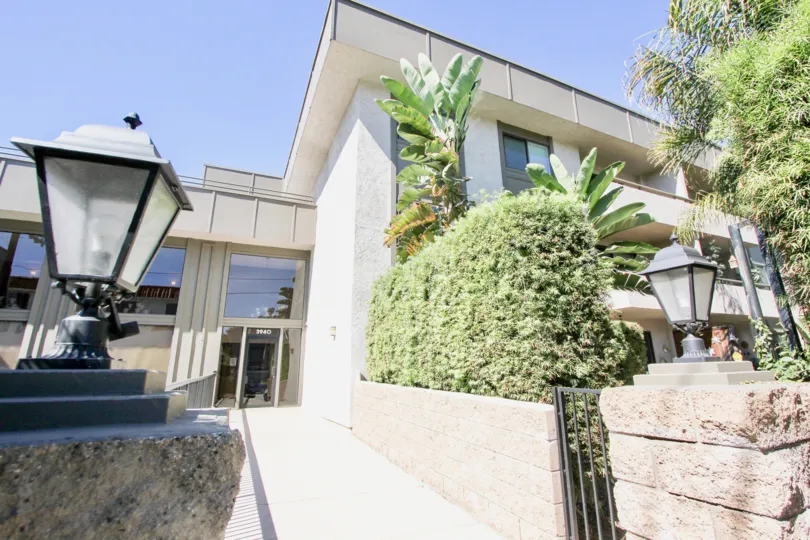 Residence entrance with lamp in front and plants over little wall in the Mission Crest Gardens