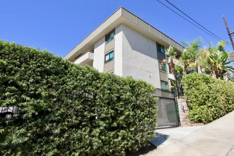 Front of residence with plants in the wall and some trees in the patio in the Mission Crest Gardens
