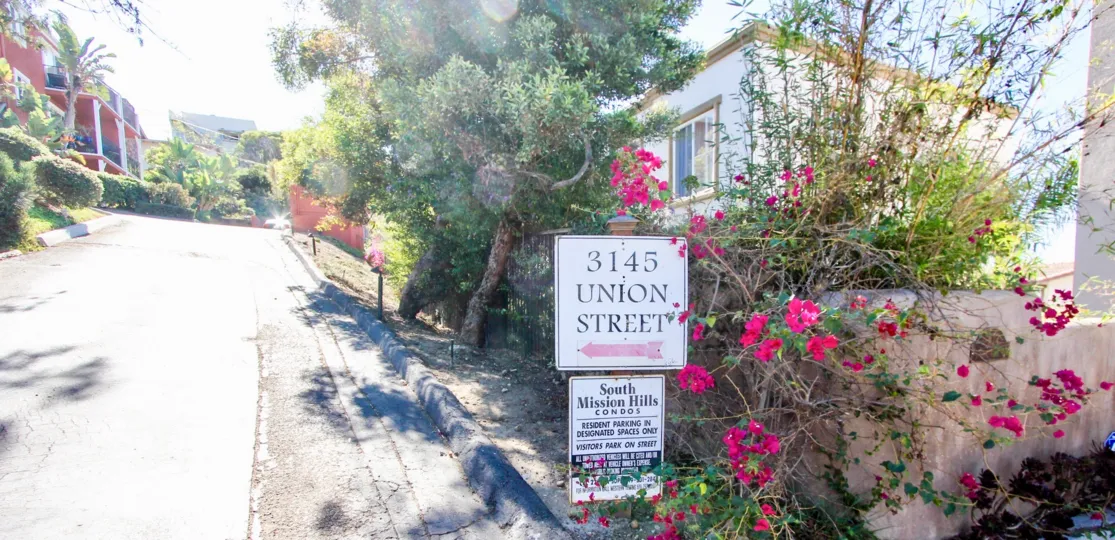 A sunny day in the area of South Mission Hills Condos, entrance, sign, flowers, street