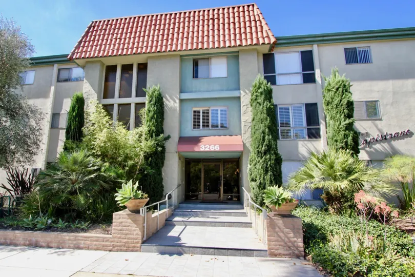 A sunny day in the area of Capostrano, entrance, condos, trees, bushes