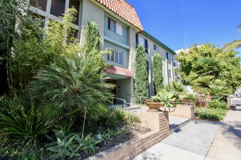 Both sides of the entrance of the apartment in The Capistrano is full of bushes and plants