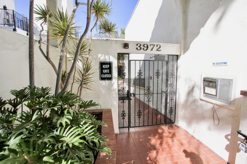 A lovely day in the Villa Bahia community of Mission Hills CA. White building with locked gate.