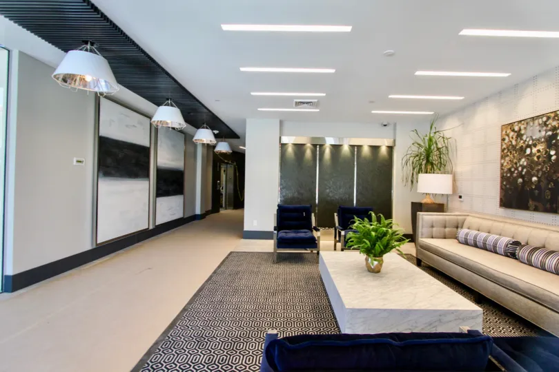 Hall in an office with big sofa some blue armchairs and some plants in the Vue on 5th