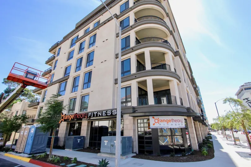 An apartment building at a street corner with a gym at the ground level during a sunny day in Vue on 5th, Mission Hills, CA