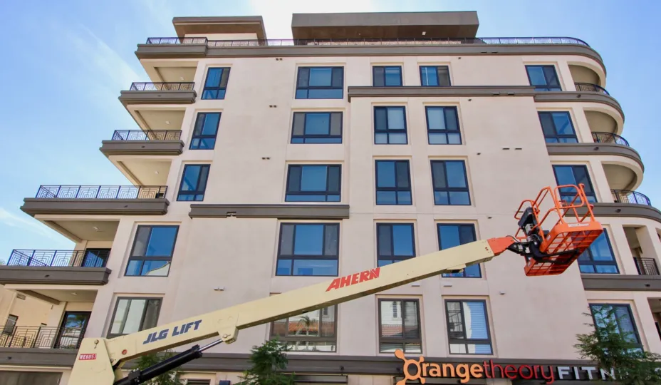 A consturction crane sits in front of an Orange Theory on the bottom floor of Vue on 5th