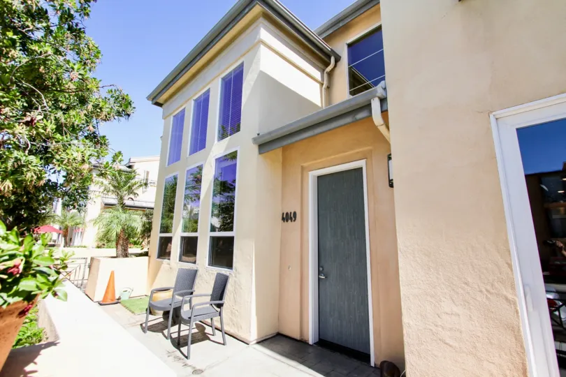 Front view of home in Mission Hills, with glass windows and chairs out front