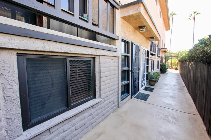 A sunny day in the area of West Walnut, walkway, wooden fence, gated entrance