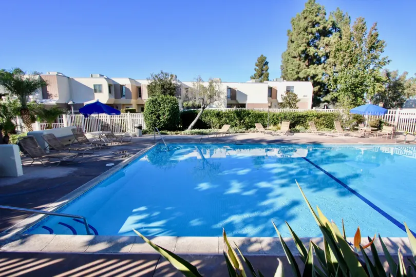 Gorgeous, large, outdoor pool with patio chairs and umbrellas in the Cerro De Alcala community of Mission Valley, California.