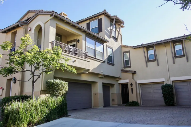 Courtyards at Escala in Mission Valley California are beautiful multi-level beige and brown stucco homes with garage space, balconies, and luscious green plants surrounding the area