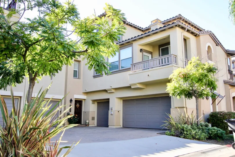 A sunny day in the area of Courtyards at Escala, garage, balcony, trees, door