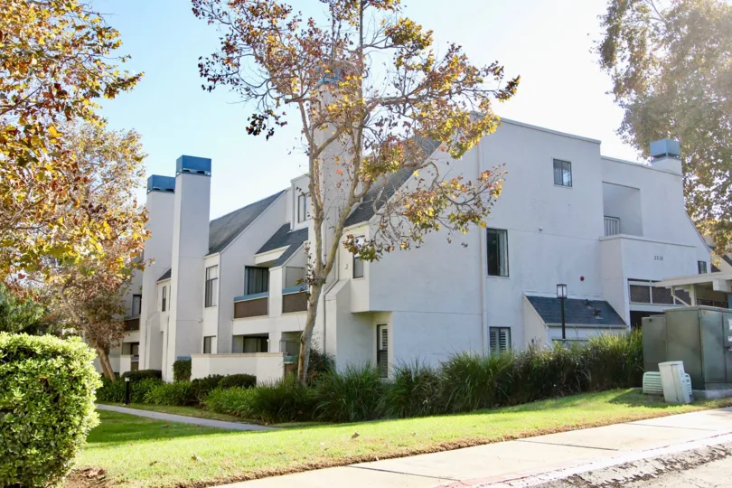 A sunny day in the area of Creekwood at River Run, condos, trees, sidewalk, grass