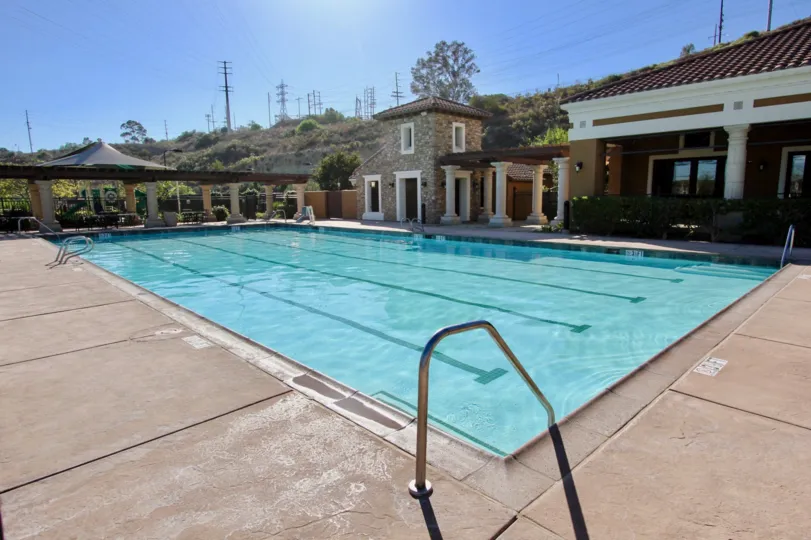 An olympic pool area with concrete patio in Escala