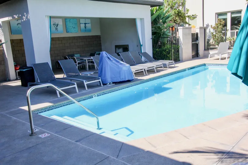 Large blue swimming pool lined with lawn chairs inside Frame and Focus in Mission Valley ca
