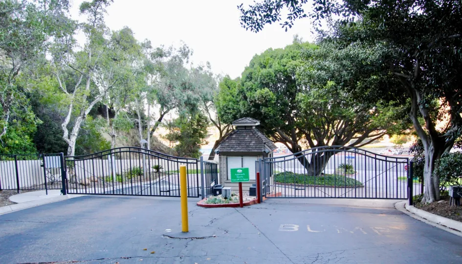 Tree lined driveway with front gate and guard hut leading to private parking area of Kensington Park Villas.