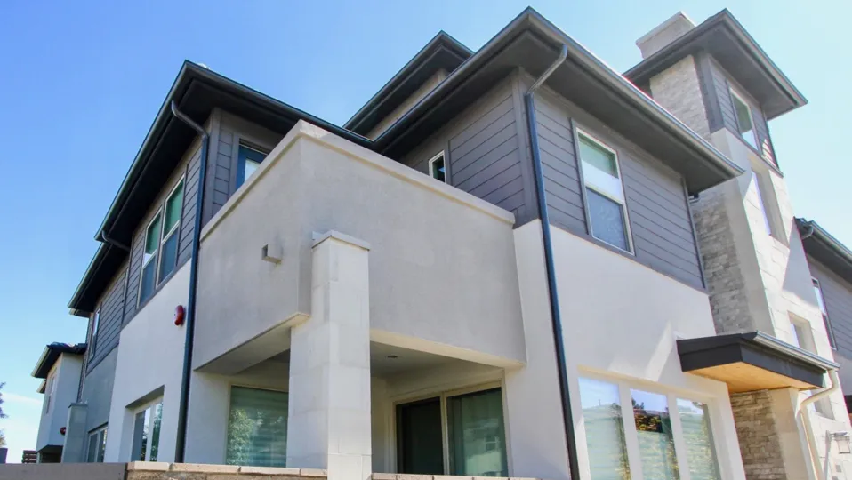 Upward angled picture looking at blue house with concrete deck