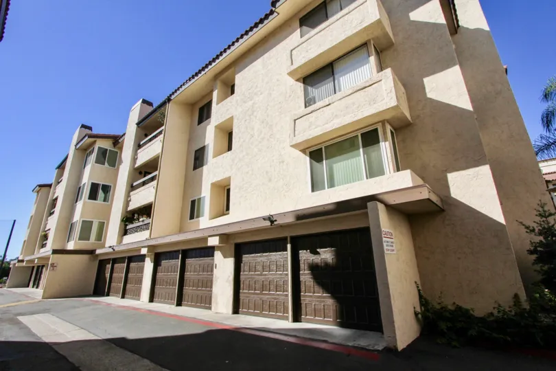 Four story brown building with old brown garage doors in Mission Greens at Mission Valley CA