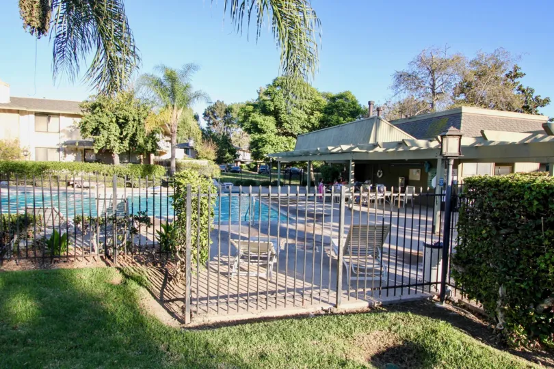 Black iron fence around a large swimming pool at Mission Playmor in MIssion Valley California