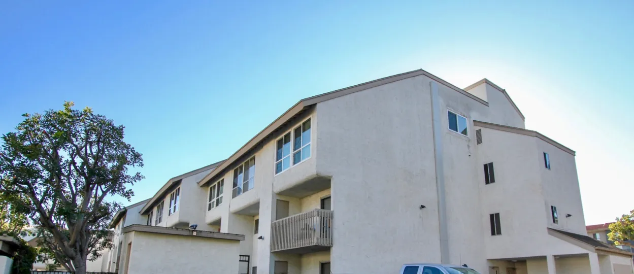 The sun sits low behind a building in the Mission Verde condos.