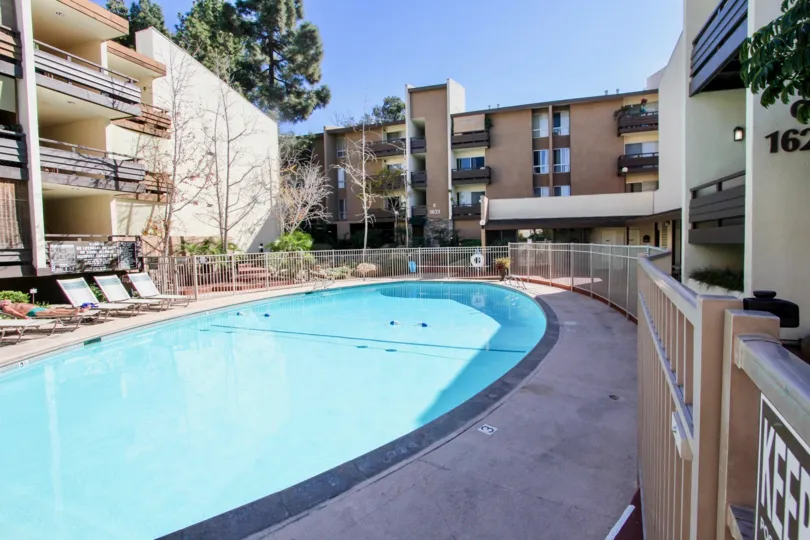 A large, oval pool sits in between three residential buildings at the Mission Village condos