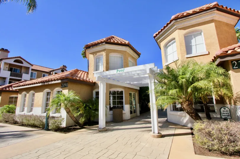 Image of stucco buildings against a blue sky: the River Colony community in Mission Valley, California.