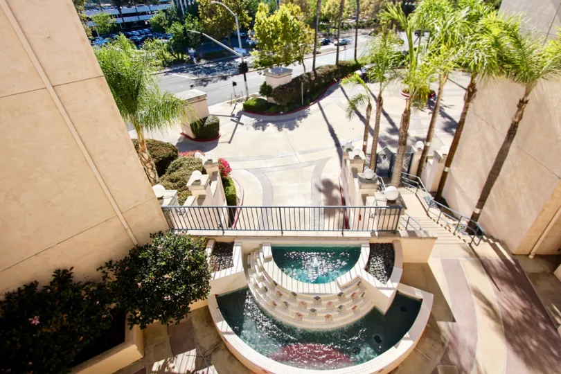 A Birds-eye view of palm trees and a fountain at River Scene community in Mission Valley, CA