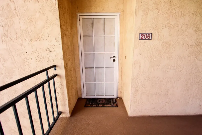 Still life image of a white front door of apartment 206 in the River Scene neighborhood