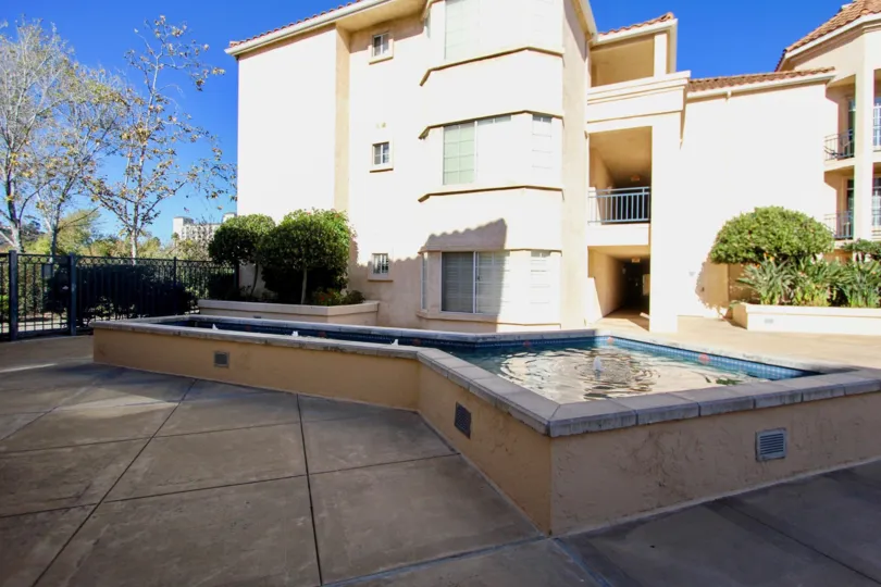 Three story, tan apartment building with swimming pool in River Scene, Mission Valley, CA