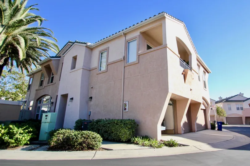 Sunny outdoor view of palm tree and two storey home in Union Square community in Mission Valley, CA
