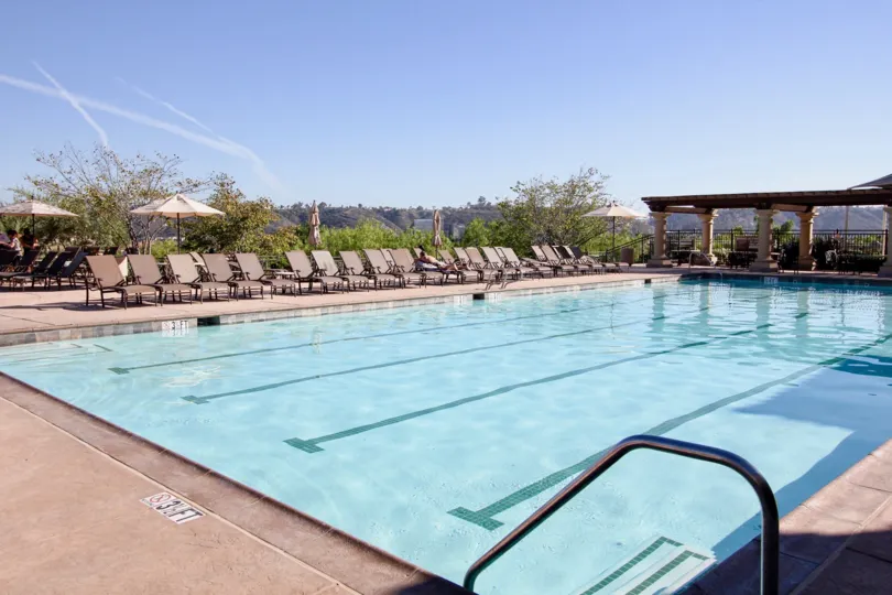 Large blue pool lined with many sun chairs at Verandas at Escala in Mission Valley CA