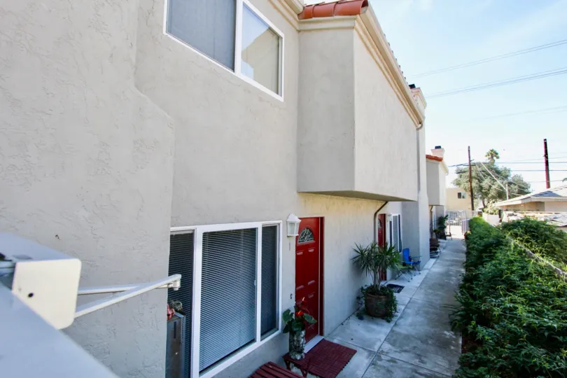 Red doors and foliage-lined walkway at 4572 Kansas St in Normal Heights, CA