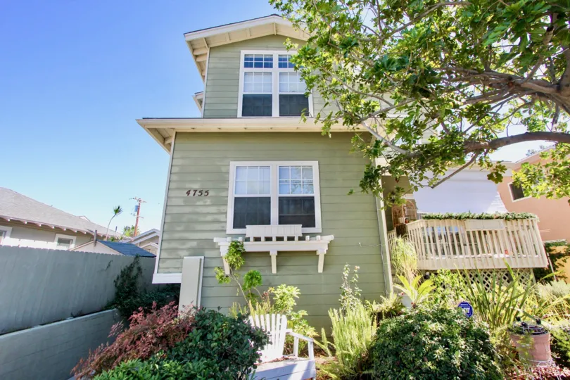 The two story 4755 Wilson house has a green exterior and nice landscape