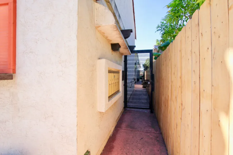 Pathway to 4772 36th St, gated access to house and a wooden fence