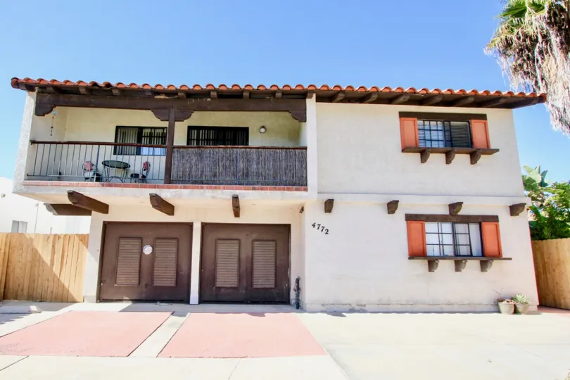 a nice simple housing with decent paint job and a wooden fence and parking in front