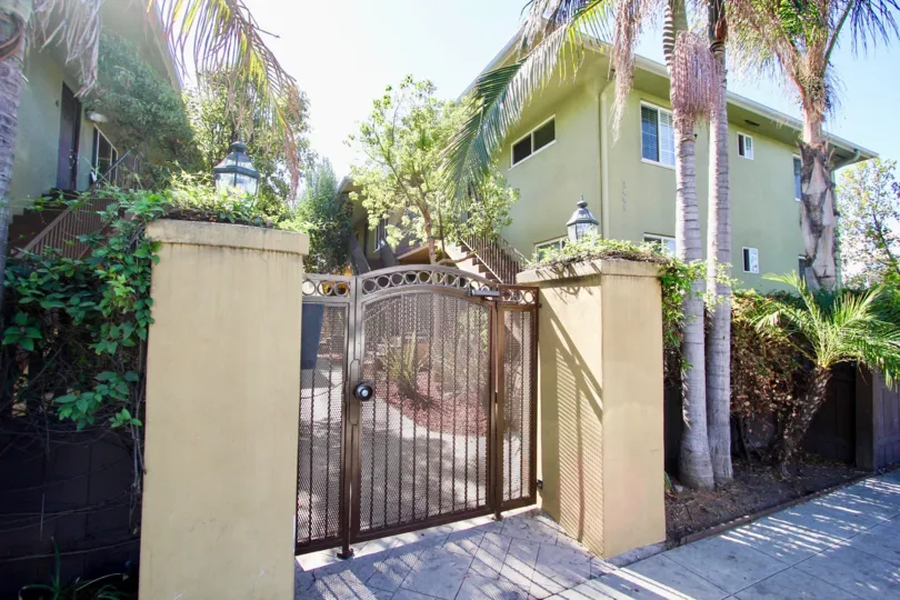 Gated entrance and palm trees to Adams Ave at the Park in Normal Heights, Ca on a sunny day.