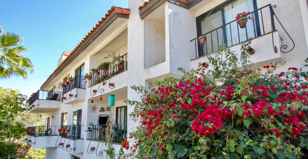 Balconies with hanging flower pots and terracotta roofs at the Casa Monterey in Normal Heights, California