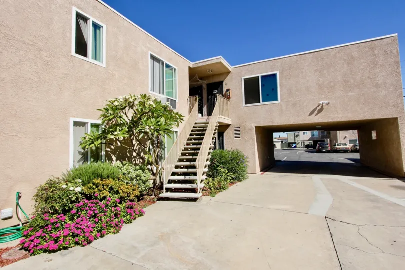 An open drive with a small garden next to a staircase leading up to an apartment door in Normal Heights in California.