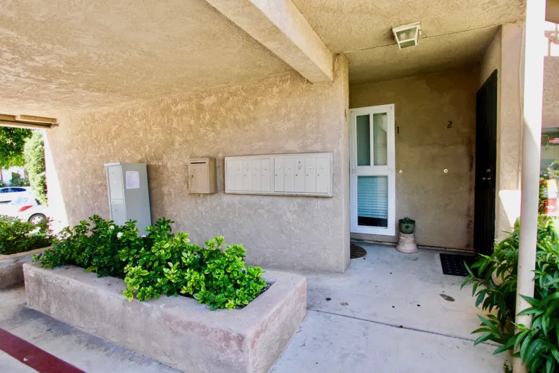 Stucco building, condo/townhome/appartment, main floor, mailboxes, landscaping,