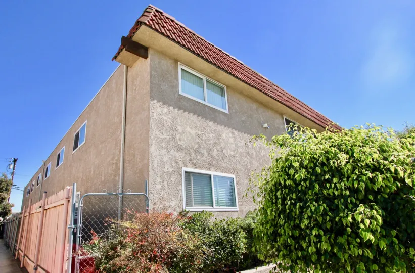 The backside of the house which have the long gates around the housewalls and the beautiful plants are planted, shows the lot of windows are there in community of Cityscape