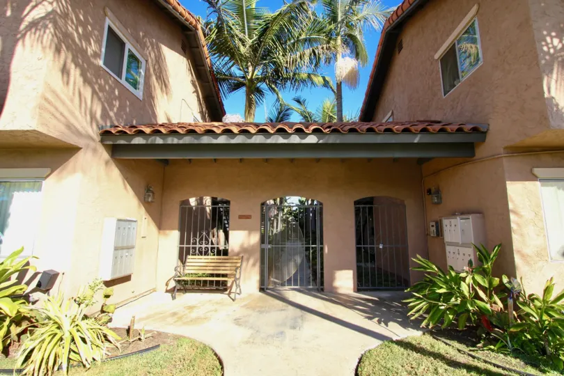 Entrance to Cleveland Avenue Condos in the Normal Heights neighborhood of San Diego, CA showing terra cotta roofs and towering palms