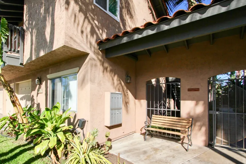 A view of the exterior of the Cleveland Avenue Condos showing the community mail box, gated entrance, and tiled roof.