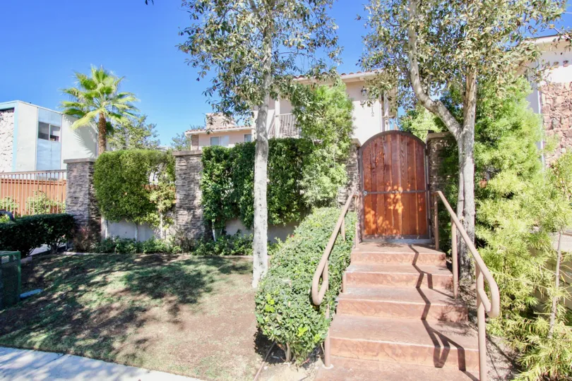 THE BUNGALOW IN THE COLLIER COURT WITH THE WOODEN DOOR, STEPS, PLANTS, TREES, GRASS