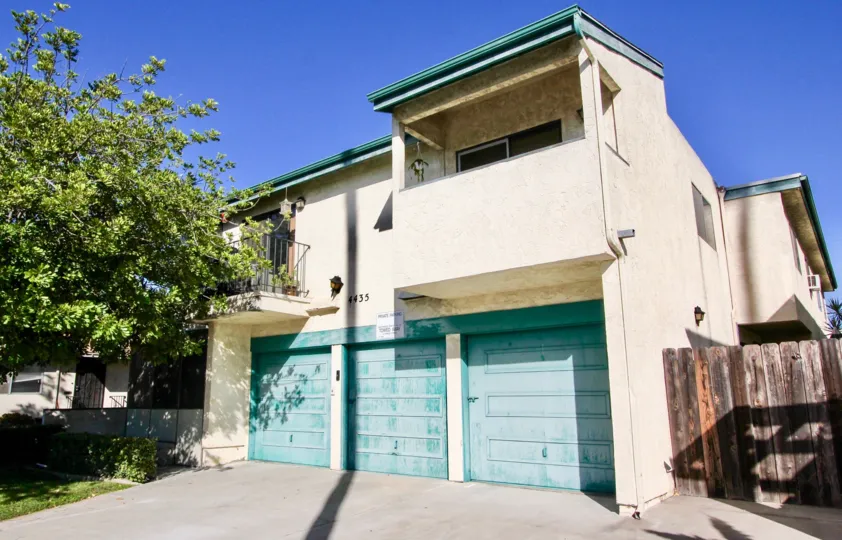 A sunny day in the area of Hamilton Street Condos, garage, wooden fence, balcony, trees, driveway