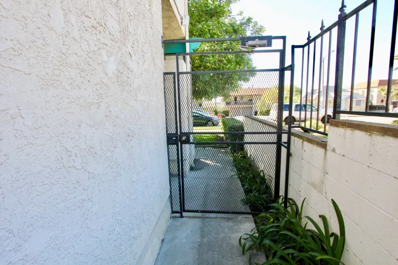 A sunny day in Hamilton Street Condos with a closed gate in an alley way.