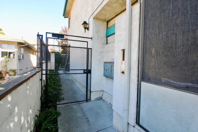 A sunny day in the area of Hamilton Street Condos, gate, fence, mailboxes, sidewalk, air conditioner, condo