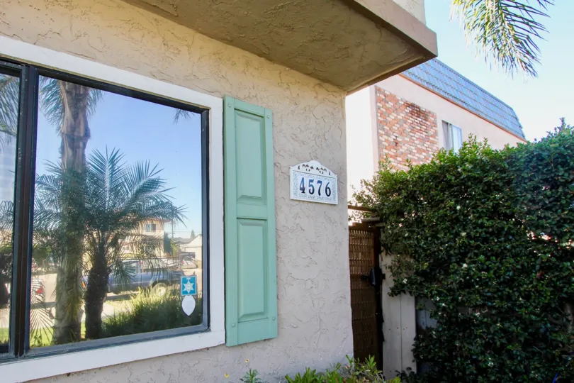 Black address on a white sign next to a reflective window at Hawley Boulevard in Normal Heights CA