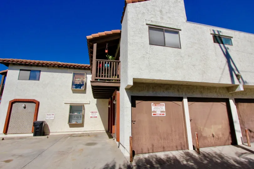 A large building with balconies and doors with metal posts in front in Hawley Villas.
