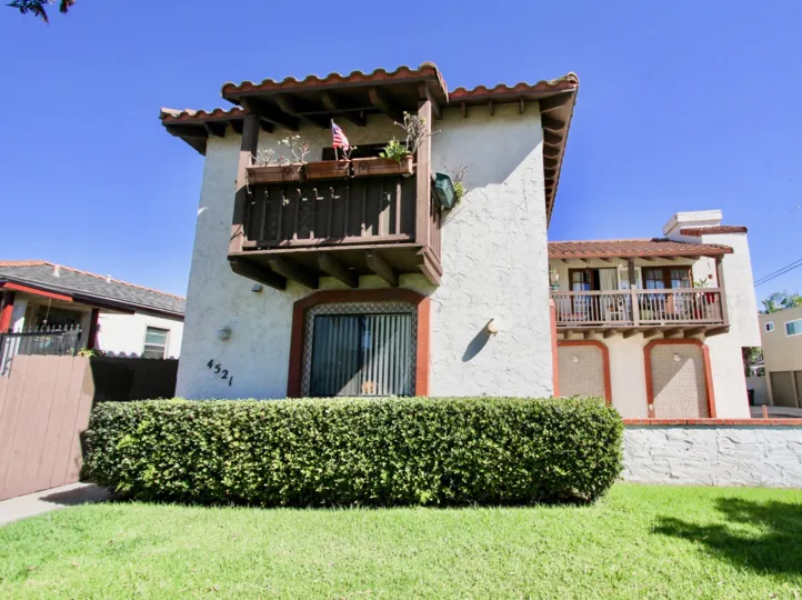 A sunny day in the area of Hawley Villas, bushes, condos, grass, fence, balconies