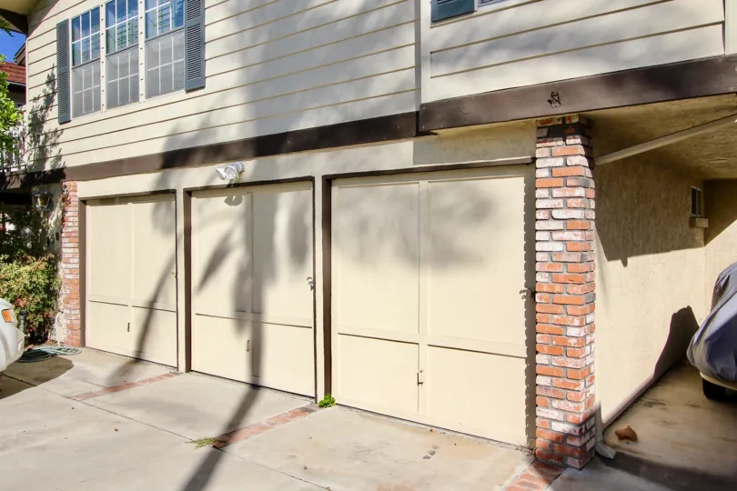 Single car garage units with decorative doors below windows with stylish shutters at Hermitage II