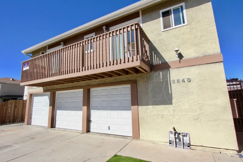 A sunny day in the area of Madison Gardens, garages, balcony, porch light, wooden fence, potted plant